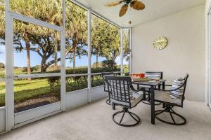 a dining room with a table and chairs and large windows at Relaxed Golfside Living with New Furnishings & Scenic Views - Palm Breeze Fairway in Gateway