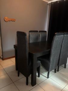a black table and chairs in a room at Ruros Guest House in Kempton Park