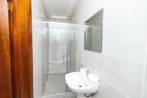a bathroom with a shower and a toilet and a sink at Luxurious townhouse behind Achimota Mall in Accra
