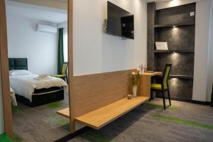 een slaapkamer met een bed, een wastafel en een bureau bij Motel Brist in Zenica