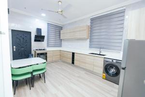 a kitchen with a sink and a washing machine at Luxurious townhouse behind Achimota Mall in Accra