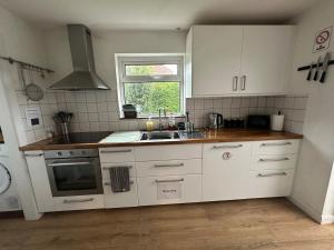 a kitchen with white cabinets and a sink and a window at 3 bedroom house, stones throw from SMH in Bristol +20 photos