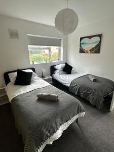 a bedroom with two beds and a window at 3 bedroom house, stones throw from SMH in Bristol
