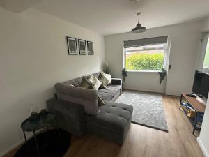 a living room with a couch and a television at 3 bedroom house, stones throw from SMH in Bristol