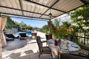 a patio with a table and chairs and a pool at HIDDEN PARADISE - Villa by Split in Žrnovnica