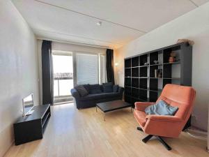 a living room with a couch and a chair at Cozy flat in Suurpelto in Espoo