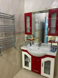 baño con lavabo blanco y armarios rojos en Baku Garden House, en Baku 30 fotos más