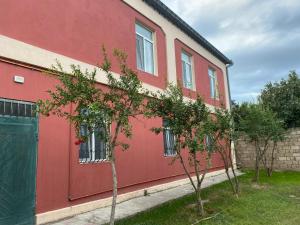 un edificio rojo con árboles delante de él en Baku Garden House, en Baku