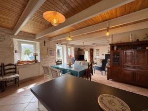 a kitchen and living room with a table and chairs at Ty Guillerm - Maison bretonne entre terre et mer in Plounévez-Lochrist