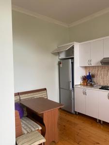 cocina con mesa de madera y cocina con nevera en Baku Garden House, en Baku