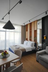 a hotel room with a large bed and a table at Madera apartments in Čačak