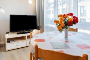 un vase de fleurs sur une table avec une télévision dans l'établissement Apartment St Pauli, à Hambourg