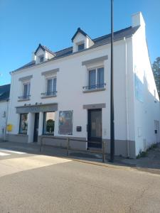 a white building on the side of a street at Vkls Appartement 1 in Languidic