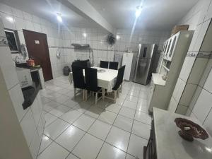 a kitchen with a table and chairs in a room at Casa Confortável in Belém