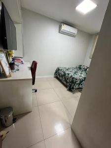 a small room with a desk and a bed in it at Casa Confortável in Belém
