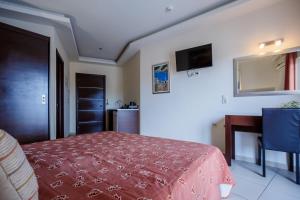 a bedroom with a bed with a red blanket at Vivian Hotel in Laganas