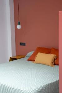 a bedroom with a bed with an orange wall at El Taller de San Martín in Águilas
