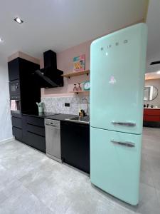 a white refrigerator in a kitchen with black cabinets at El Taller de San Martín in Águilas