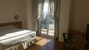 a bedroom with a bed and a large window at Hotel Excelsior in Lanciano