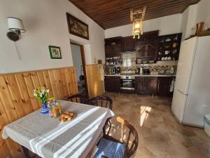 a kitchen with a table and a refrigerator at Vidám Vándor Vendégház in Parád