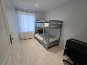 a small room with two bunk beds in it at Appartement proche Walibi in Les Avenières