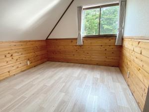 an attic room with wooden paneling and a window at 天然プラネタリウムcottage星空D棟 in Nasushiobara