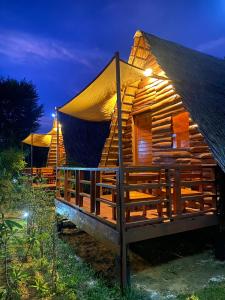 Una cabaña de madera con techo de paja por la noche en Phu Aunna, en Ko Phayam