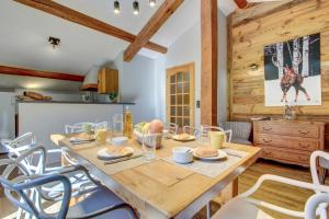Un comedor con mesa y sillas de madera. en Mas Verjus, en Morzine
