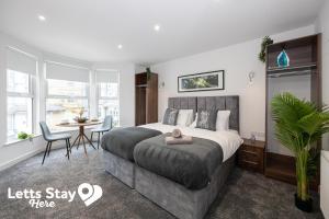 ein Schlafzimmer mit einem Bett und einem Tisch und Stühlen in der Unterkunft Eden Bay Serviced Apartments - Eden in Morecambe