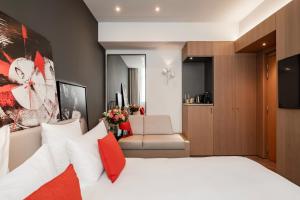 una camera d'albergo con un letto e un soggiorno di Le Cinq Codet a Parigi Altre 83 foto