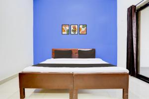 un lit dans une chambre avec un mur bleu dans l'établissement Hotel O Shree Mayaa, à Gwalior 21 autres photos