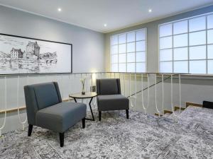 una sala de espera con dos sillas y una mesa en Mercure Hotel Dortmund Centrum, en Dortmund