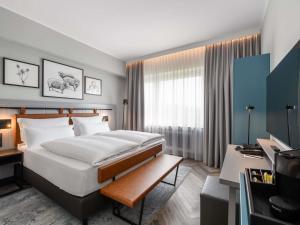 a hotel room with a large bed and a desk at Mercure Hotel Dortmund Centrum in Dortmund +87 photos