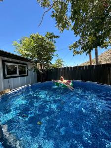a man laying on a boogie board in a swimming pool at Joshua Tree - Under the Stars-Pool, Spa & Fire pit in Yucca Valley