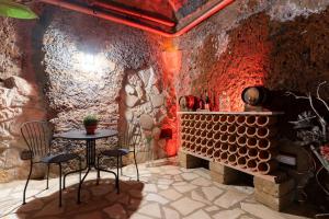 a room with a table and chairs in a stone wall at Le Segrete del Sangallo in Civita Castellana