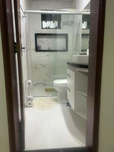 a bathroom with a toilet and a glass shower at Casa Confortável in Belém