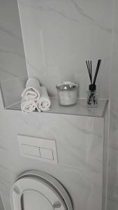 a white toilet in a bathroom with towels on a shelf at Luxury Apartments Black Diamond in Ši Selo +18 photos