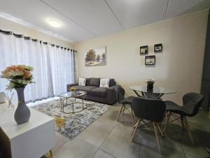 a living room with a couch and a table at Nat's Villa in Midrand