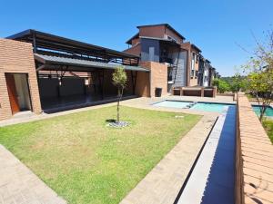 a house with a swimming pool and a yard at Nat's Villa in Midrand
