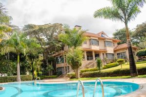 a house with a swimming pool and palm trees at selvasara suites in Nairobi
