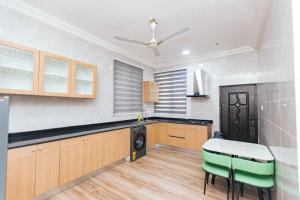 a kitchen with a table and green chairs in it at BM Properties in Accra
