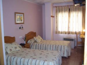 pokój hotelowy z dwoma łóżkami i oknem w obiekcie Hotel Mesón el Castillo w mieście Bañeres de Mariola