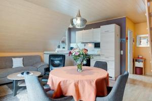 Una sala de estar con una mesa con un jarrón de flores encima. en Ferienwohnung 2 Haus Schmiedeweg, en Bad Krozingen 9 fotos más