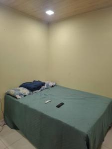 a bed in a room with a green comforter at Apartamento cop 30 Belém in Belém