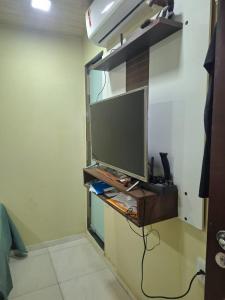 a flat screen tv on a stand in a room at Apartamento cop 30 Belém in Belém