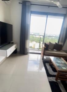 a living room with a large window and a television at Oval View Residence by C in Colombo