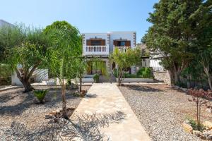 a garden with trees and a house in the background at Le Soleil De Lindos - Luxury Villa with Swim Spa in Lindos