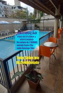 a sign on a balcony next to a swimming pool at Pousada Parque Suites - Estacionamento e Piscina in Guarujá