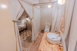 a bathroom with a sink and a bed in a room at Sahara Camp Excursions in Merdani +32 photos