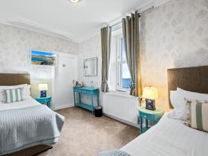 a bedroom with two beds and a window at No. 1 Charlotte Street in Port Ellen